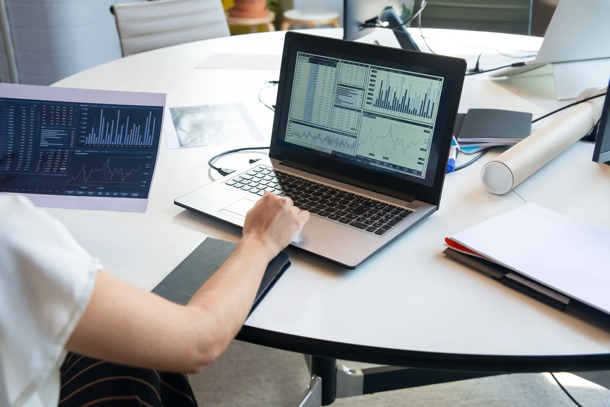 Checking store reports and charts on a laptop during routine maintenance